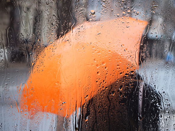 orange umbrella through rainy window